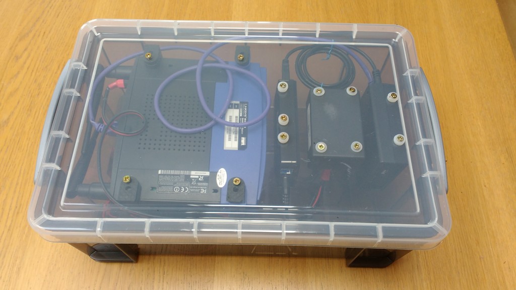 The main equipment is attached to the lid of a plastic storage box, battery and other devices are loose inside.